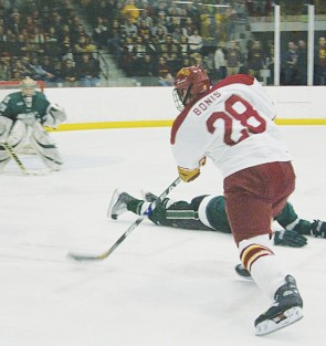 All Tied Up: Freshman Kyle Bonis shoots past a fallen Michigan State University opponent during Friday’s game. Fans filled the sold-out stadium to see the Bulldogs beat the Spartans 4-1. The 2-3 loss in East Lansing the next day kept the two teams tied for second in the Central Collegiate Hockey Association. Photos By: Kate Dupon | Photographer