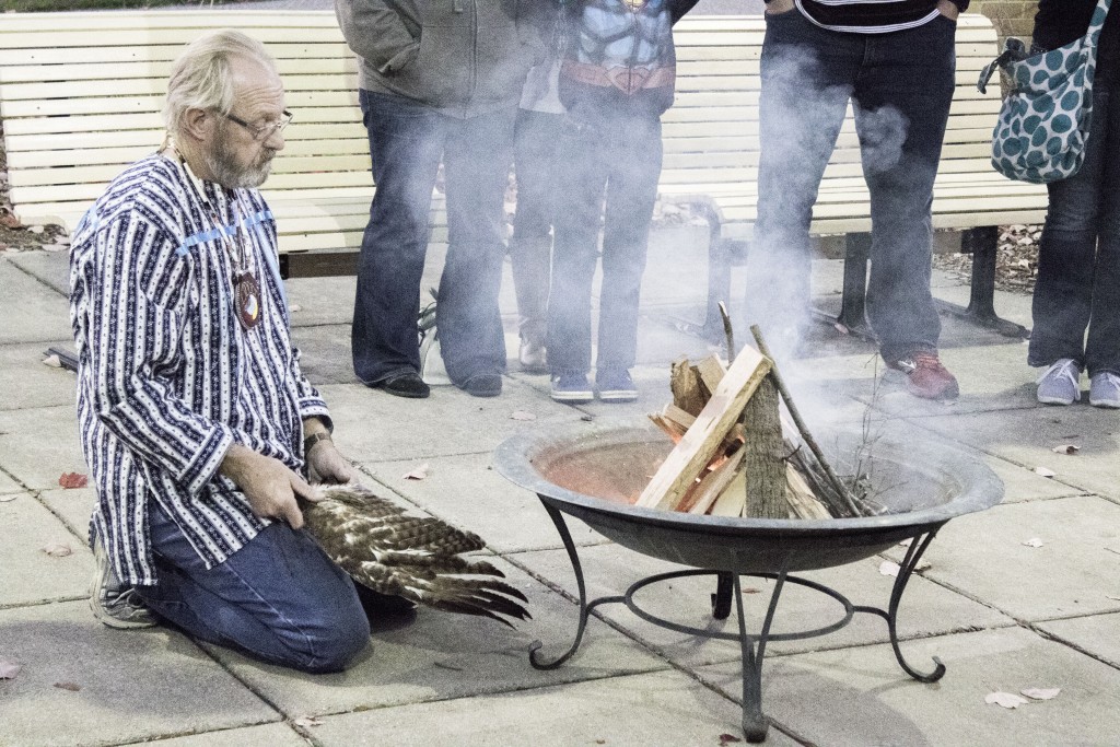 Tribal expert Bill Fuchs fans a flame before students at Circle Tribal Nations’ Ghost Supper event.
